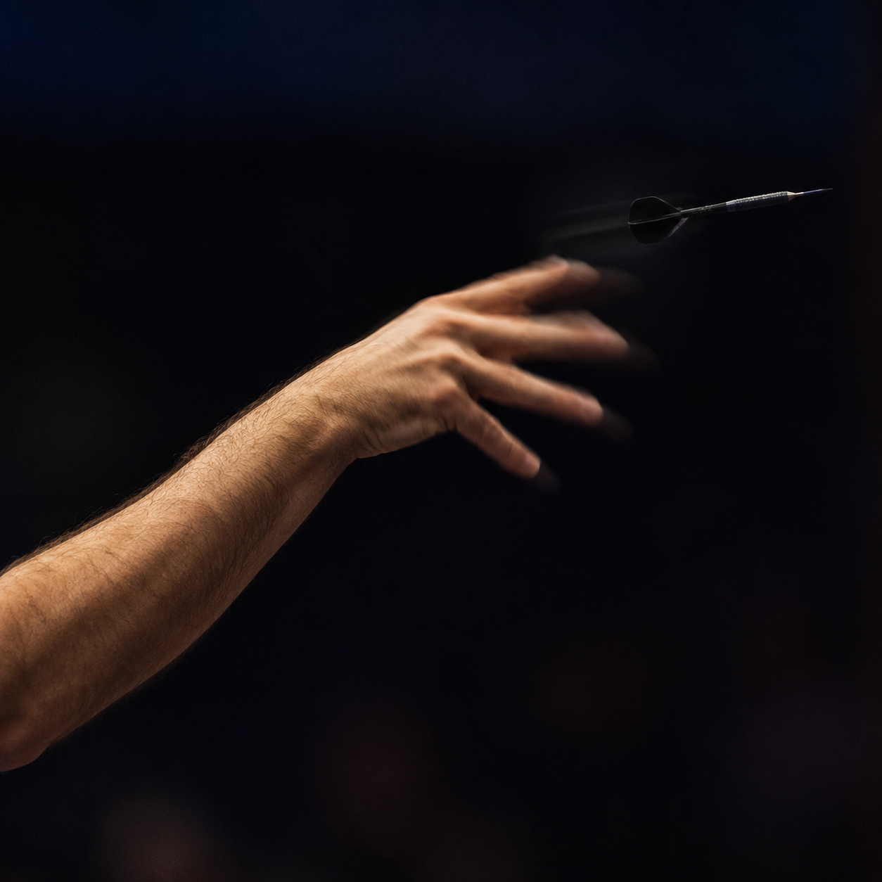 A mature darts player preparing to throw