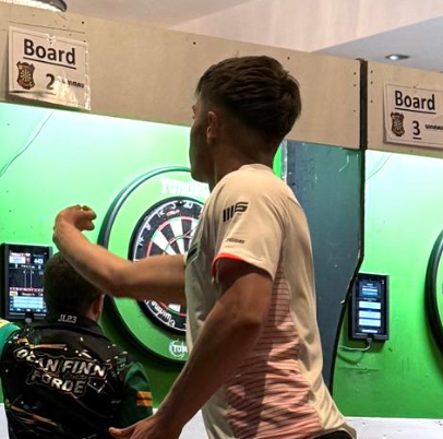 A mature darts player preparing to throw